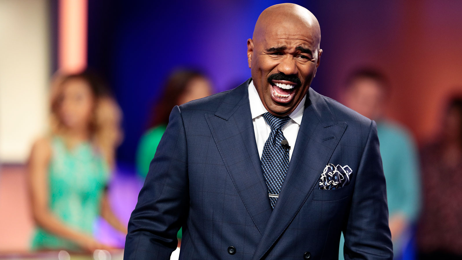 Steve Harvey laughing on the set of Family Feud.
